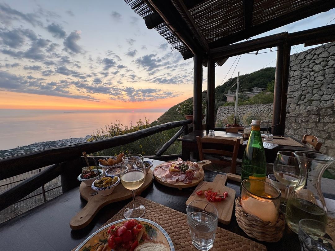 Sunset dining experience on a terrace overlooking the Mediterranean Sea with local charcuterie and wine service.